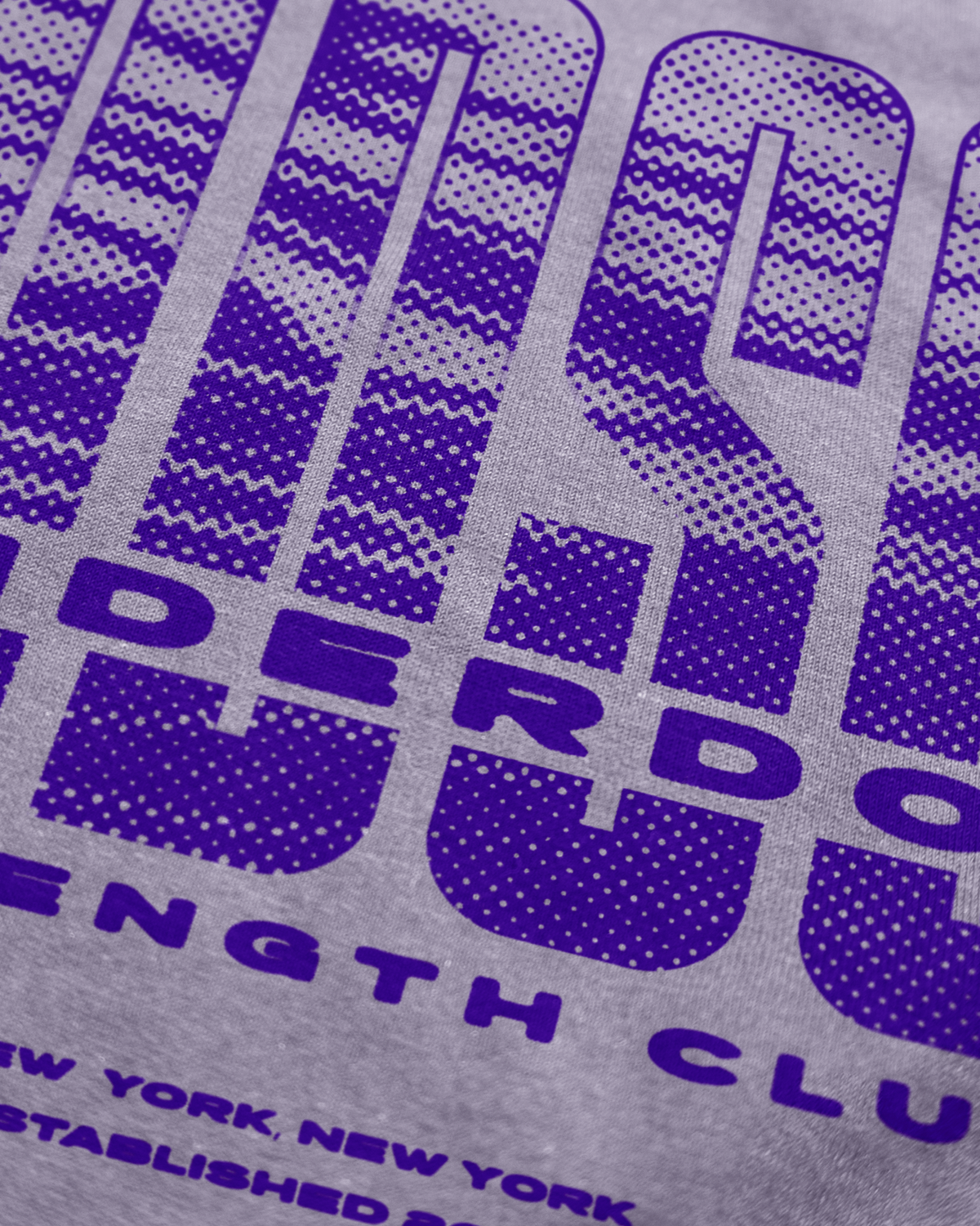 Gray t-shirt with purple text and logo, featuring 'Underdog Strength Club' branding.
